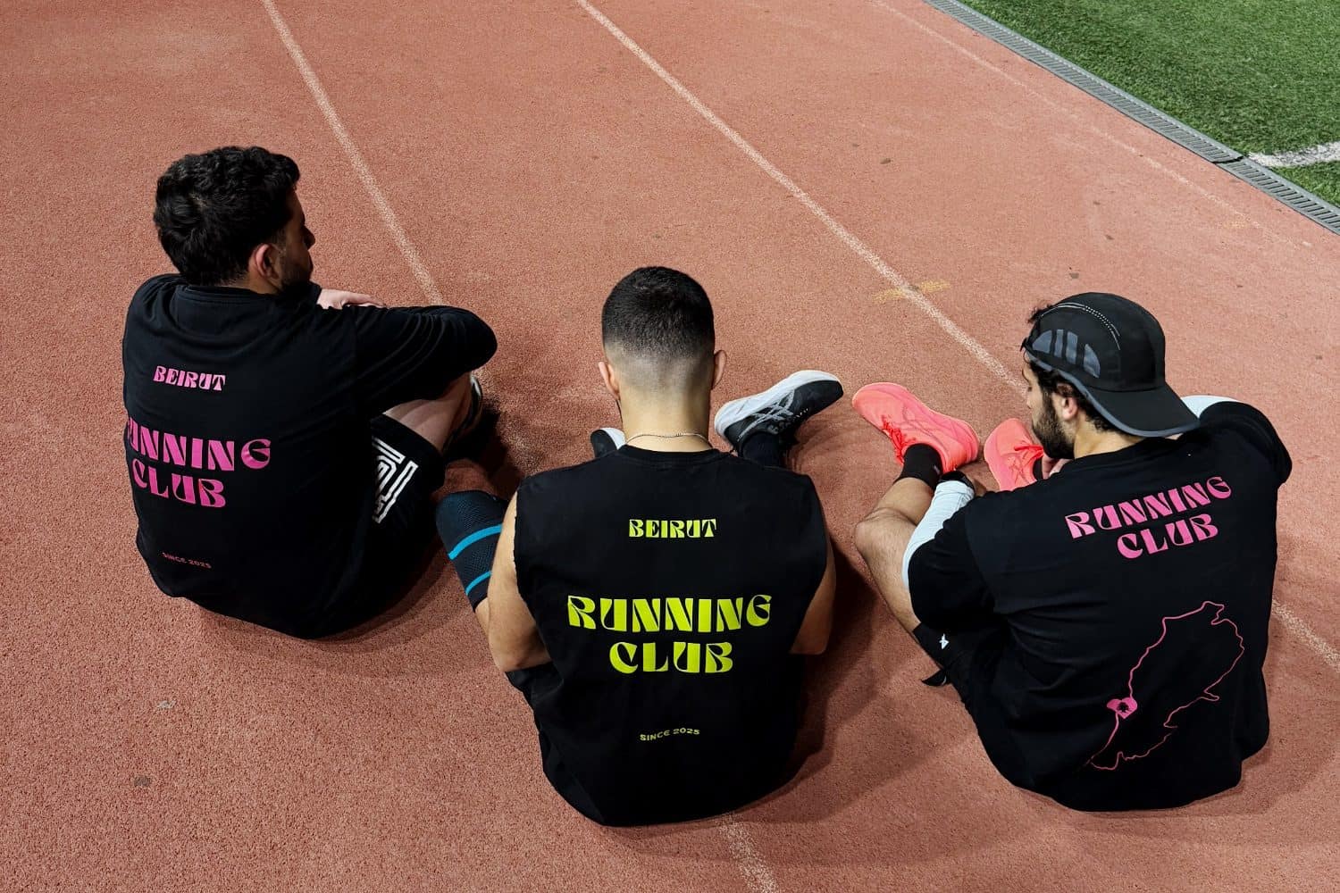 Three Run Club Beirut members sitting on a running track after a session